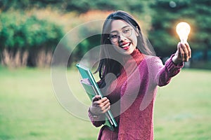 Creative young woman hold shinning light bulb.