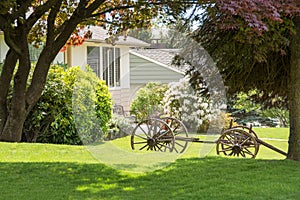 Creatively landscaped front yard with old horse vehicle on green lawn