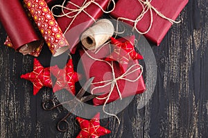 Creatively wrapped and decorated christmas presents in boxes on wooden background. Copy space.