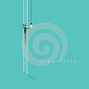 Creativity business concept with businessman standing on ladder screwing in lightbulb.