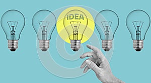 Creativity and coming up with ideas, brainstorming. Concept of inventing concepts, new ideas. The hand touching the bulb