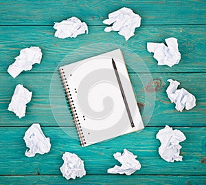 Creativity concept - notepad, pencil and crumpled paper on blue