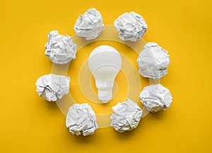 Creativity ideas with lightbulb and paper crumpled ball