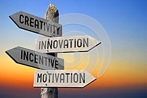 Creativity, innovation, incentive, motivation - wooden signpost, sunset sky