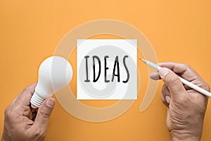 Creativity inspiration,ideas concept with lightbulb and notepad