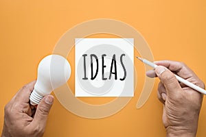Creativity inspiration,ideas concept with lightbulb and notepad photo