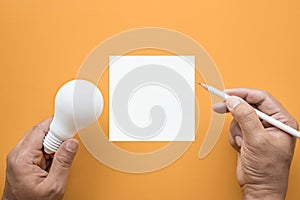 Creativity inspiration,ideas concept with lightbulb and notepad photo