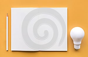 Creativity inspiration,ideas concept with lightbulb and notepad photo