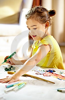 Creativity in progress. an adorable little girl making a mess while painting.