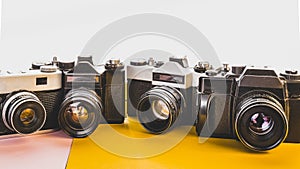 Creativity Retro Technology Concept. Vintage Film Cameras On Yellow And Pink Background, Front View