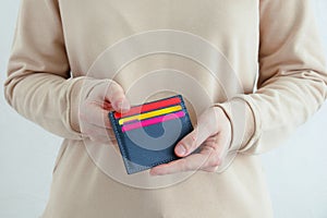 Credit bank cards in a gray business card holder in hands of a caucasian woman. White background
