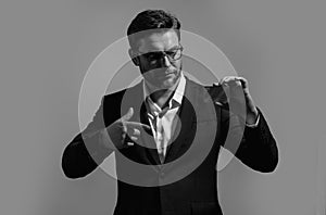 Credit card concept. Caucasian millennial successful 40s business man holding banking card isolated on gray background