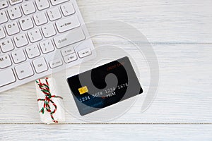 Credit card, keyboard and christmas presents on table flat lay, copy space