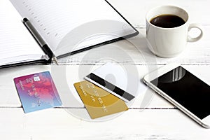 Credit card, keyboard, smartphone and coffee cup on wooden background