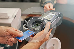 Credit card, machine and hands of customer for payment to cashier for shopping, point of sale and checkout. Transaction