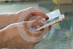 Credit card and mobile phone in hands on the table