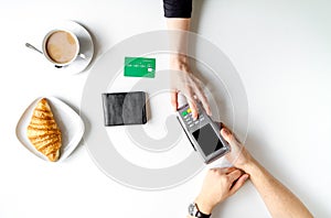 Credit card payment in cafe on white table background top view