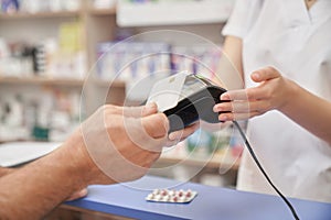 Credit card payment for pills with terminal in pharmacy.