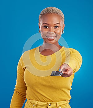 Credit card, payment portrait and happy woman in a studio with success from paying a bill. Isolated, blue background and