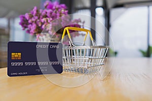 Credit card and shopping basket on wooden table. online shopping, online payment