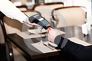 Credit card terminal for cashless payments. Customer holds credit card