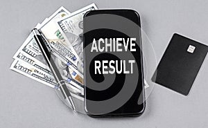 Credit card and text ACHIEVE RESULTS on smartphone with dollars and pen. Business