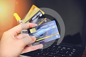 Credit card and using laptop easy payment online shopping concept - electronic card in hand for pay online