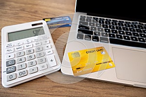 Credit cards, calculators and laptops are on the desk