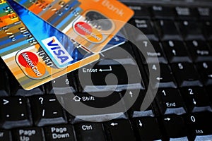 Credit cards on computer keyboard with brand logos VISA and MASTERCARD