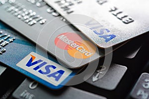 Credit cards on computer keyboard with VISA and MasterCard brand logos