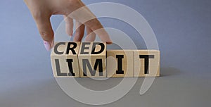 Credit and limit symbol. Businessman hand turnes wooden cubes and changes words limit to credit. Beautiful grey background.