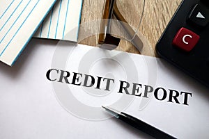 Credit report document with pen, calculator and glasses