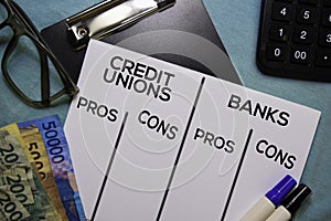 Credit Unions Vs Bank text on Document form isolated on office desk. Pros and cons