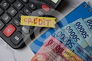 Credit write on sticky note and rupiah banknotes isolated on Office Desk