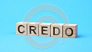 credo - text on wooden blocks, business concept, blue background