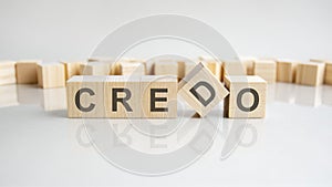 Credo text on a wooden blocks, gray background photo