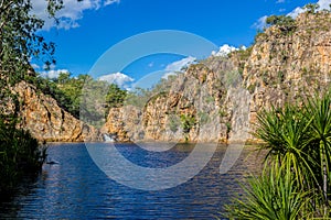The creek carrying the clear water of Edith Falls Lelyin with the rock wall reflecting in the water, Nitmiluk National Park,