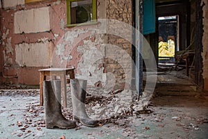 Creepy, abandoned, old room with boots on the floor in building located in the Chernobyl ghost town