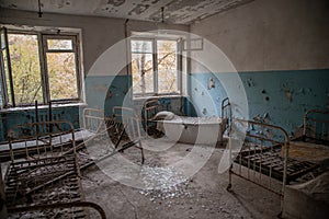Creepy, abandoned room with beds and windows in building located in the Chernobyl ghost town