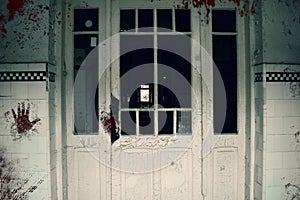 Creepy bloody door of the haunted asylum. Abandoned and decayed building of psychiatric hospital photo