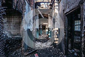 Creepy corridor of burnt abandoned building. Ruined ceiling and roof