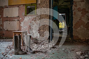 Creepy, dark, abandoned, old room with boots on the floor in building located in the Chernobyl ghost town
