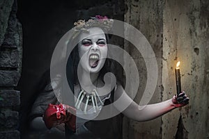 Creepy dead bride with candle screaming. Halloween scene