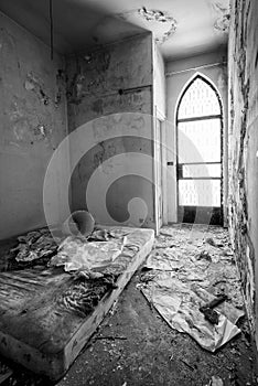 Creepy derelict bedroom with rusty mattress on the floor in an abandoned house
