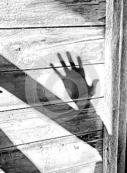 Creepy hand shadow reaching out in an old abandoned barn.