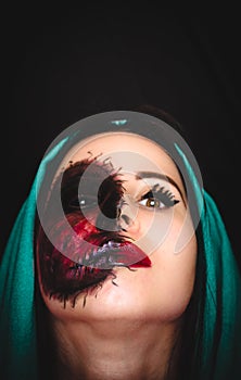 Creepy portrait of a woman with a cursed mark on her face on dark background with copy space
