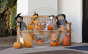 Creepy Pumpkins with Faces, Scary Scarecrows on Bench Are Traditional Halloween Decor