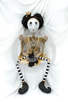 Creepy steampunk doll sitting facing forward. Legs apart. Vertical.