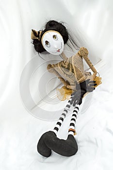 Creepy steampunk doll sitting with legs outstretched. Vertical. Tilted.