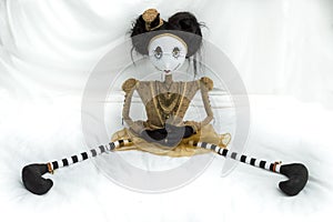 Creepy steampunk doll sitting with legs wide apart.
